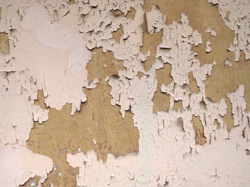 Abblätternde alte Farbschicht auf einer verwitterten Wand — Beispielfoto